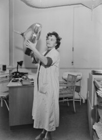 Ilse Boese, Leiterin des Leuchtstofflabors, prüft einen Kolben, Dezember 1961.