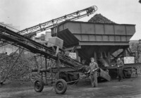 Kohlentransport am Kesselhaus. Deutlich zu erkennen ist, dass die Kohle per Bahn geliefert und dann mit Hilfe eines Förderbands ausgeladen und auf dem Hof gelagert wurde, April 1961.