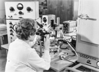 Eine Mitarbeiterin an einem Messplatz bei einer optischen Prüfung, September 1965.