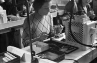 Junge Frau in Alltagskleidung beim Sockelmontieren. Foto, um 1953.